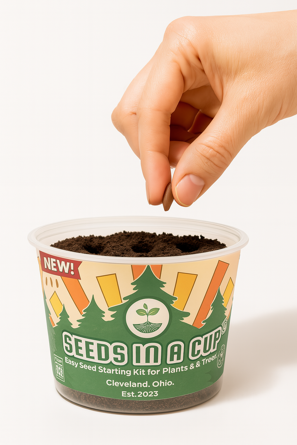 Hand planting seeds into a 'Seeds in a Cup' kit on a white background how to grow